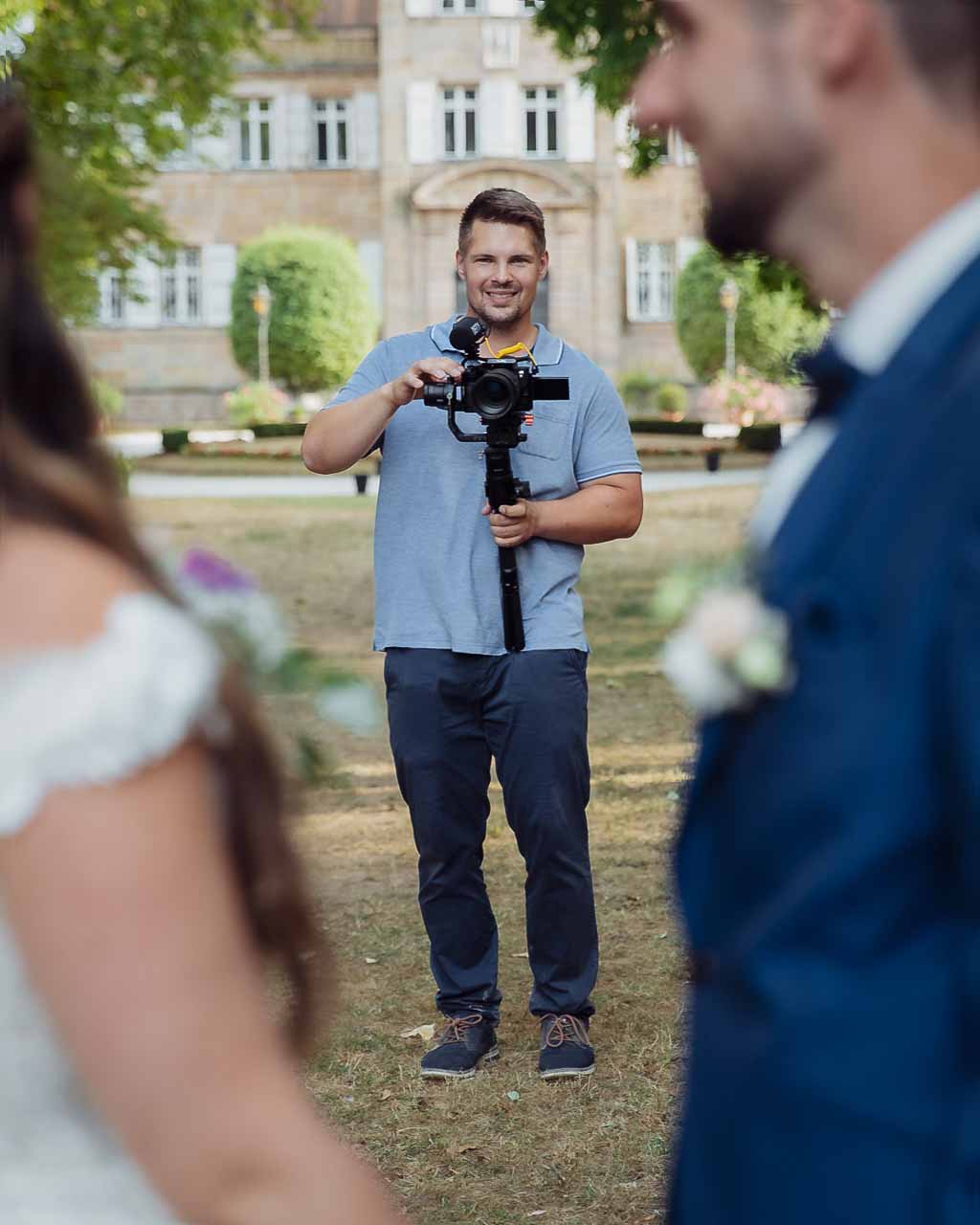 Hochzeitsvideograf aus Ingolstadt, unscharf im Vordergrund ein fokussiertes Brautpaar, symbolisiert professionelle Hochzeitsfilme und Hochzeitsvideos in München und Umgebung.